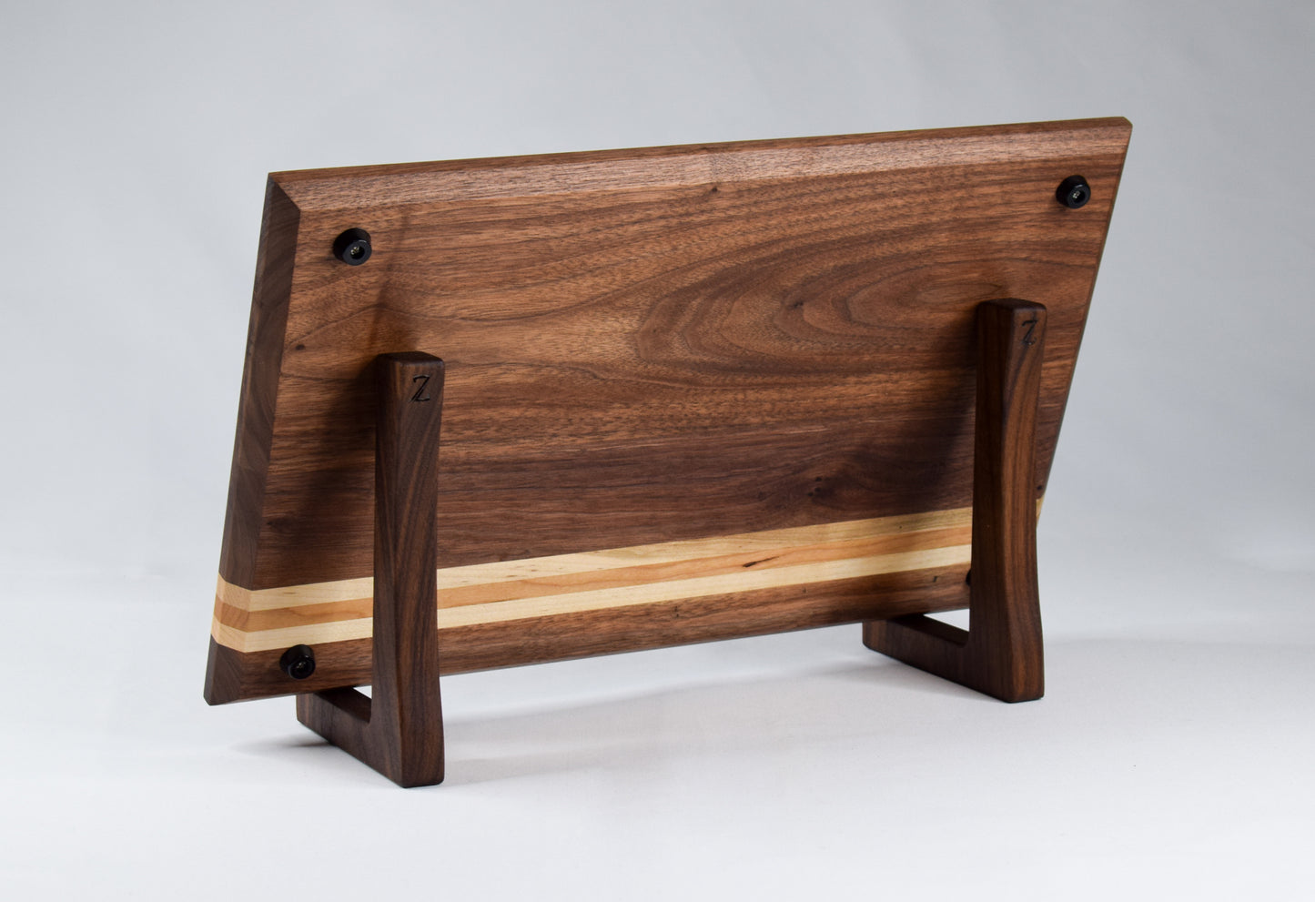 This striped cutting board is the perfect addition to any kitchen with its simple alternating stripes of maple and cherry hardwoods against a walnut backdrop. Complete with non-skid rubber feet for a sturdy cutting surface, this cutting board will not only provide functionality for the chef in your home, but will also serve as a statement piece in the kitchen.
