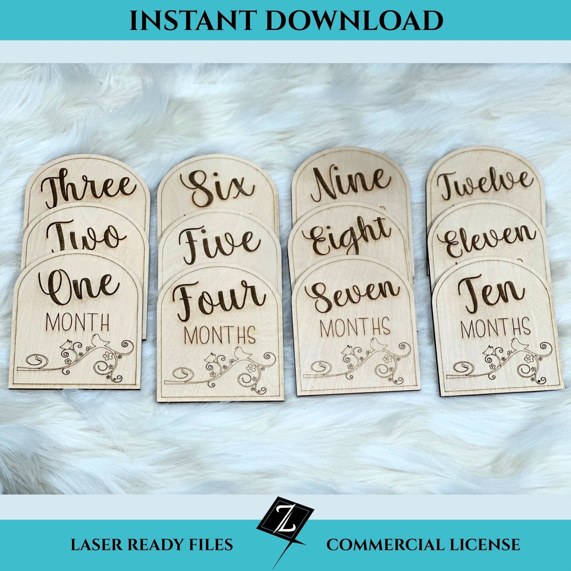 Set of twelve engraved wooden milestone signs for babies, labeled One Month through Twelve Months in elegant script, displayed on white faux fur. Each sign features rounded tops and floral embellishments, shown as a digital file for laser cutting.