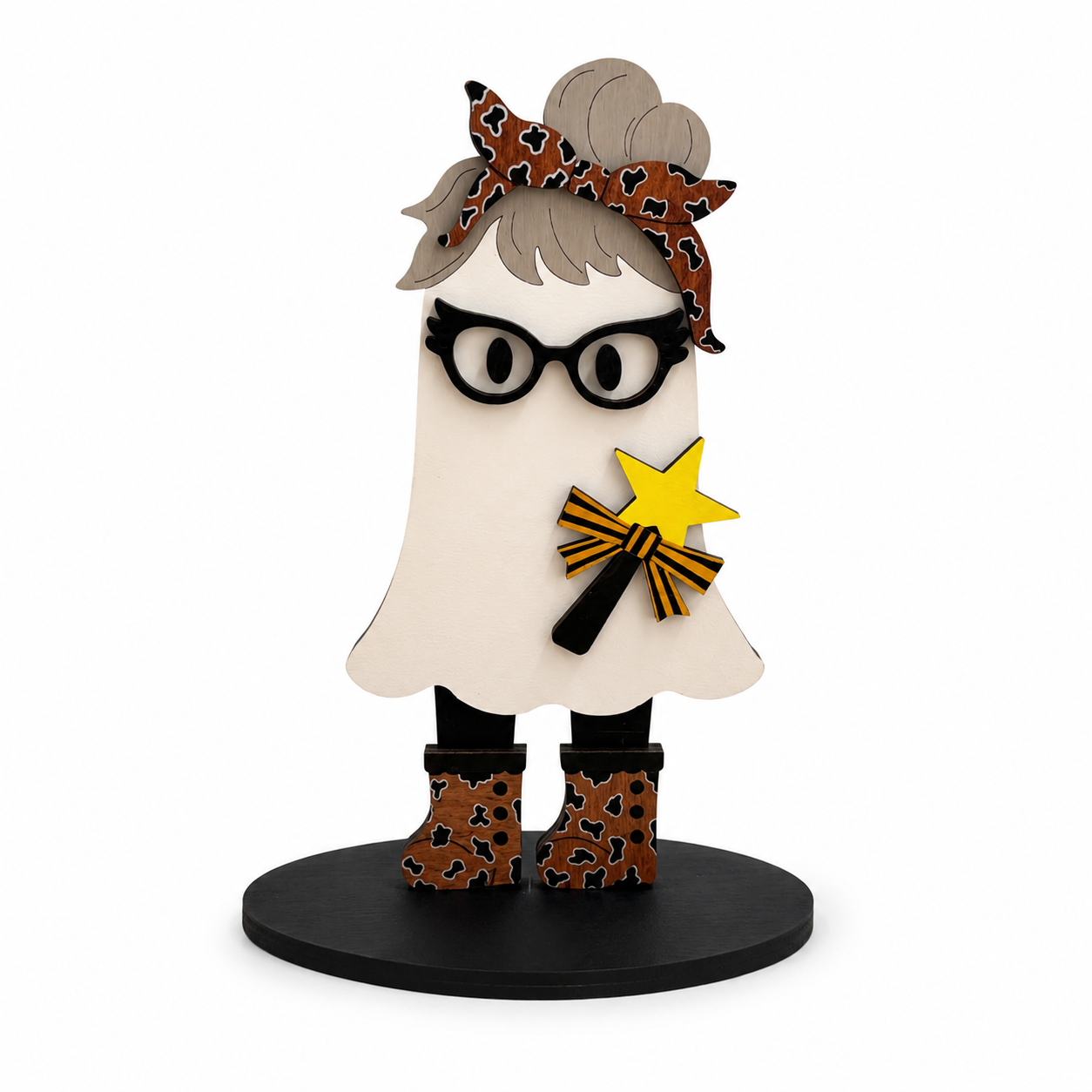 A stylized ghost figurine with black-rimmed glasses, a brown leopard-print headband, black boots, and a yellow star wand, standing on a round black base against a plain white background.