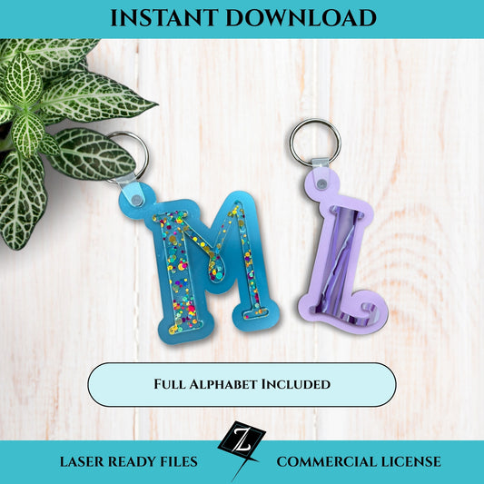 Two colorful monogram keychains; one featuring the letter 'M,' the other, a letter 'L.' Keychains are on a on a light wooden surface with a plant in the corner.