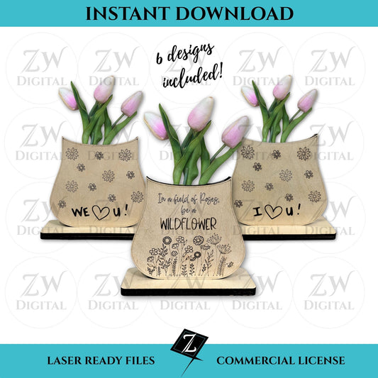 Three laser-cut layered wooden vases made from birch plywood, featuring engraved message of "In a field of roses, be a wildflower," "I love you," and "we love you" with scored floral details, displayed with pink tulips; one vase stands on a wooden base and the other hangs with twine.