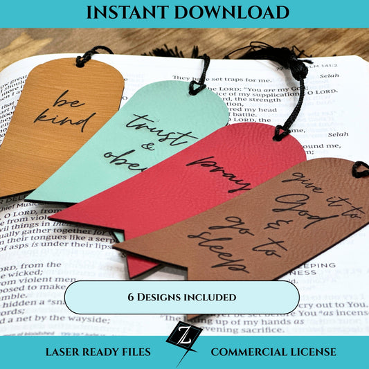 Colorful leatherette bookmarks with black tassels engraved with motivational phrases or Biblical references.  Bookmarks are laying on an open Bible atop a wooden desk.  