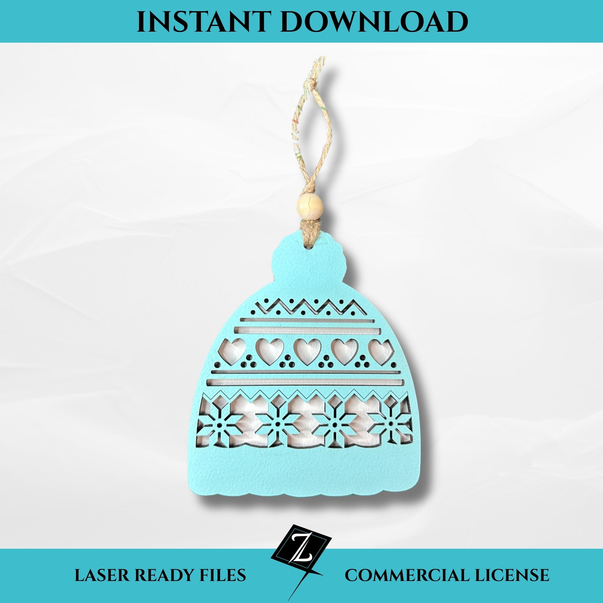 Layered laser-cut ornament shaped like a winter hat with hearts, zigzags, and snowflake cutout details, painted light blue and topped with a wooden bead and string hanger.