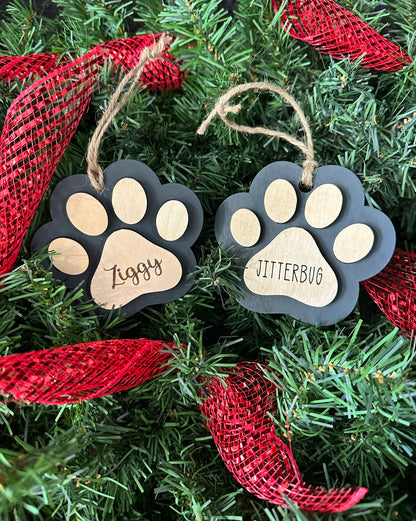 Personalized wood Christmas ornament in the shape of a paw print and customized with pet name.