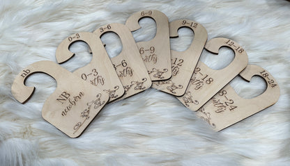 Seven closet hangers to sort baby clothes from sizes newborn through 24 months.