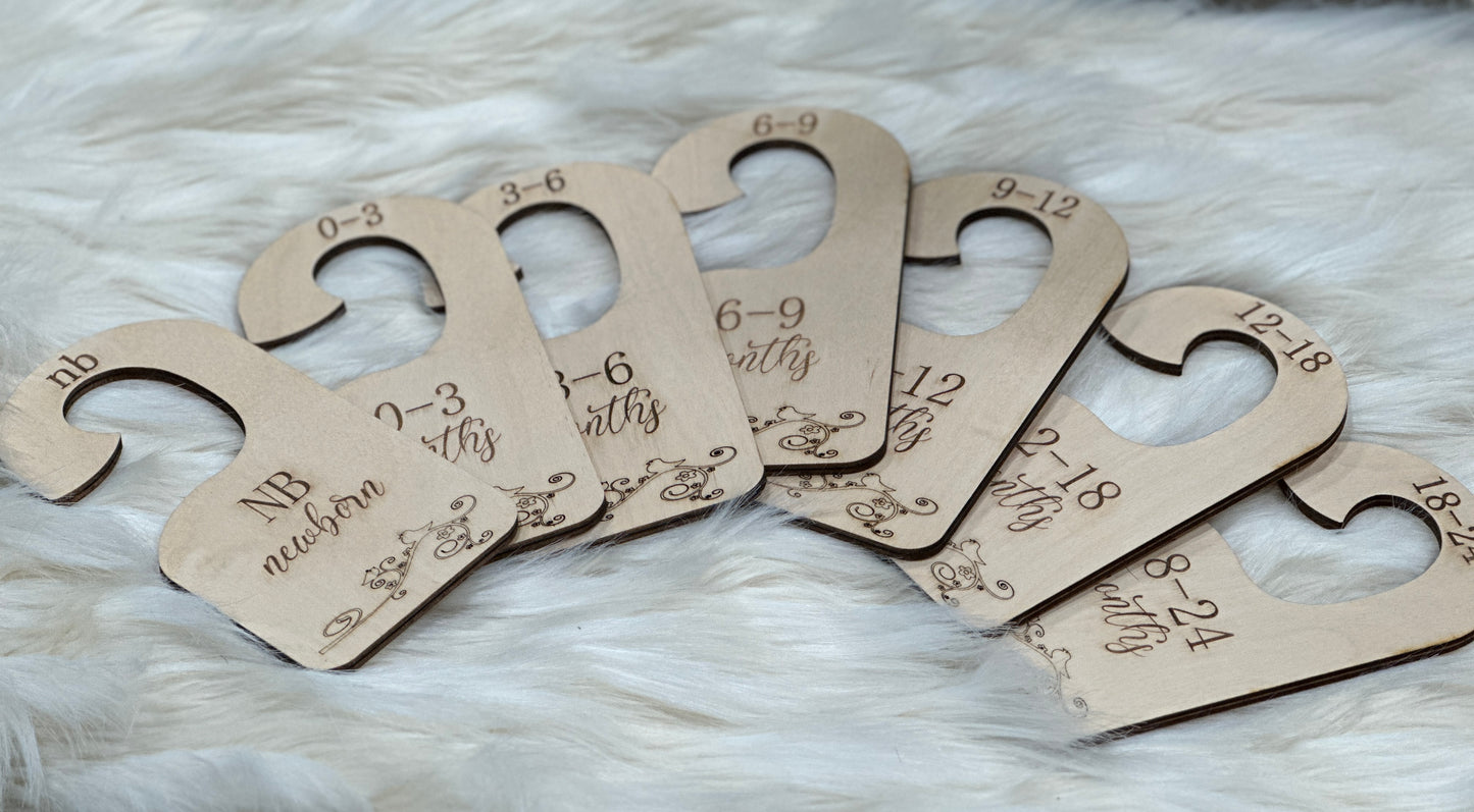 A spread of handmade wooden Baby Closet Dividers with sizes from Newborn to 24 months.