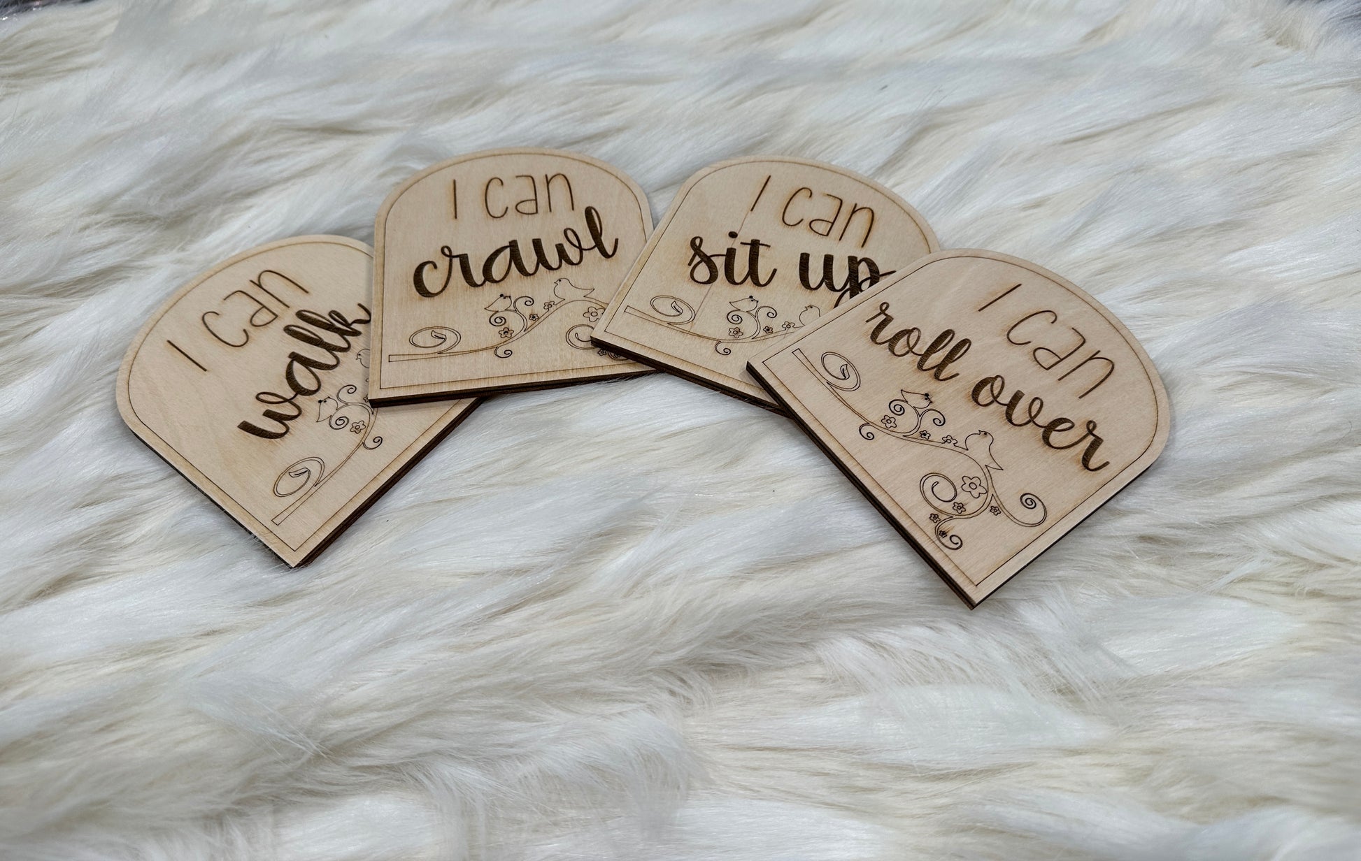 Handmade wooden baby milestone cards featuring "I can walk," "I can crawl," "I can sit up," "I can roll over."