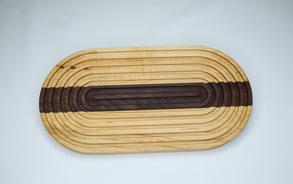 Light colored wood bread board with dark stripe down the middle.