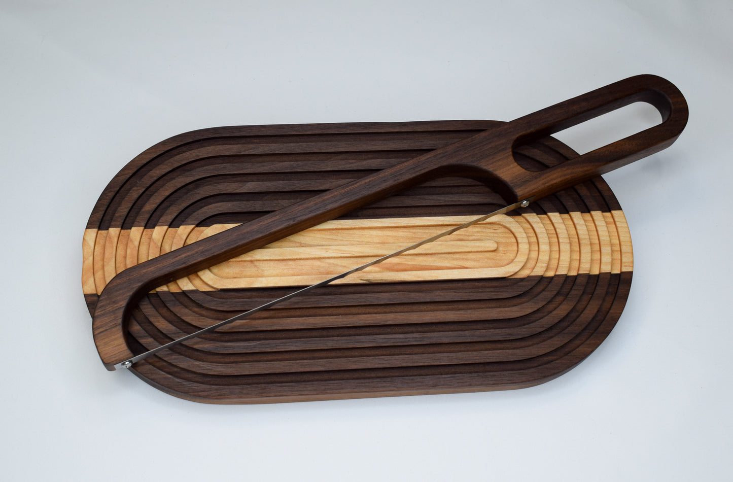 Handmade bread board made of domestically sourced hardwoods paired with a bow bread knife.