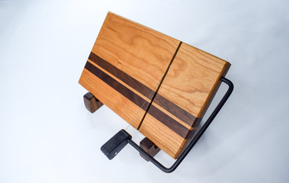 A handmade wooden cheese board with a cherry walnut wood stripe.