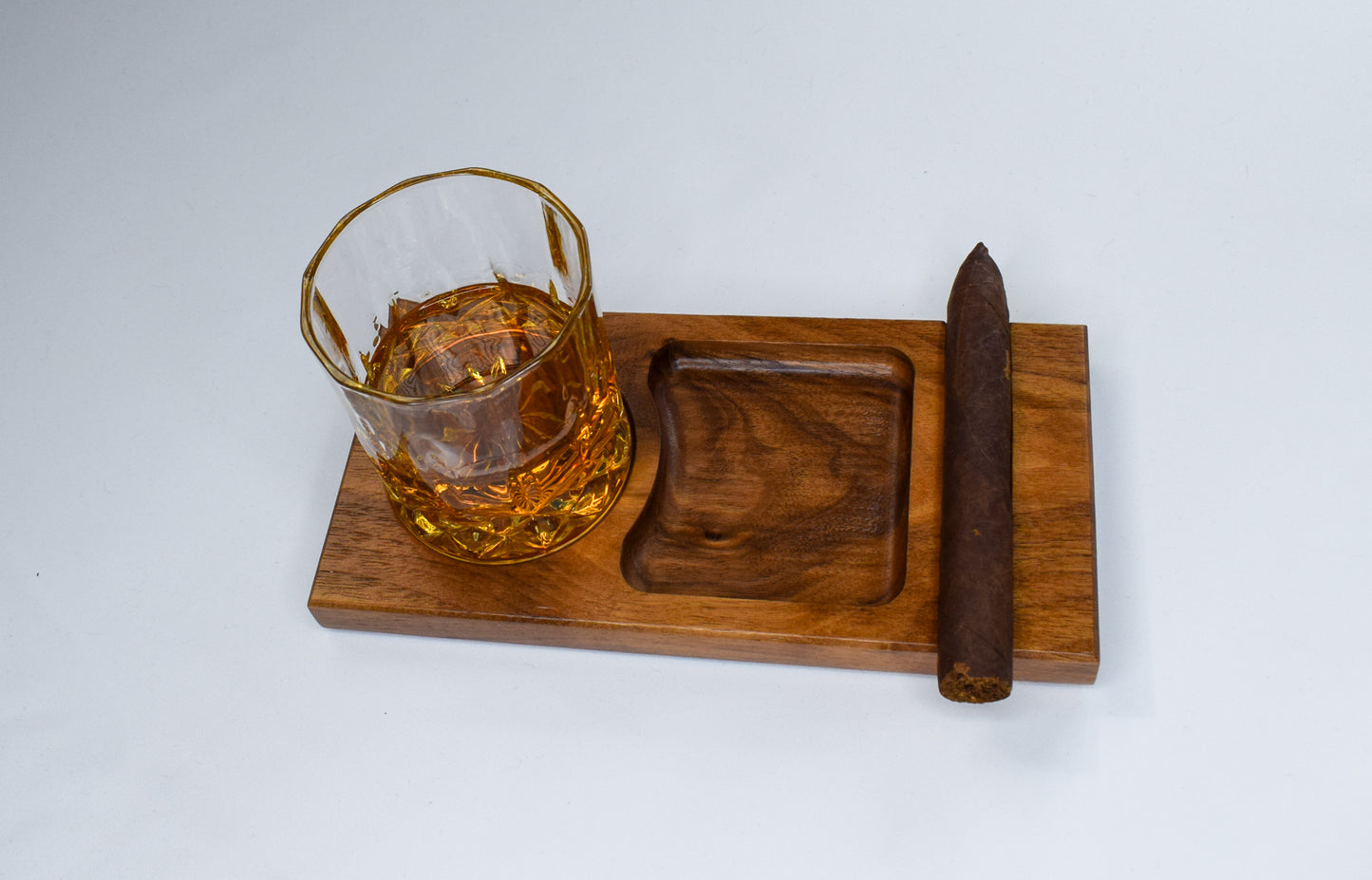 A tray handmade with walnut wood used to hold bourbon and cigar.