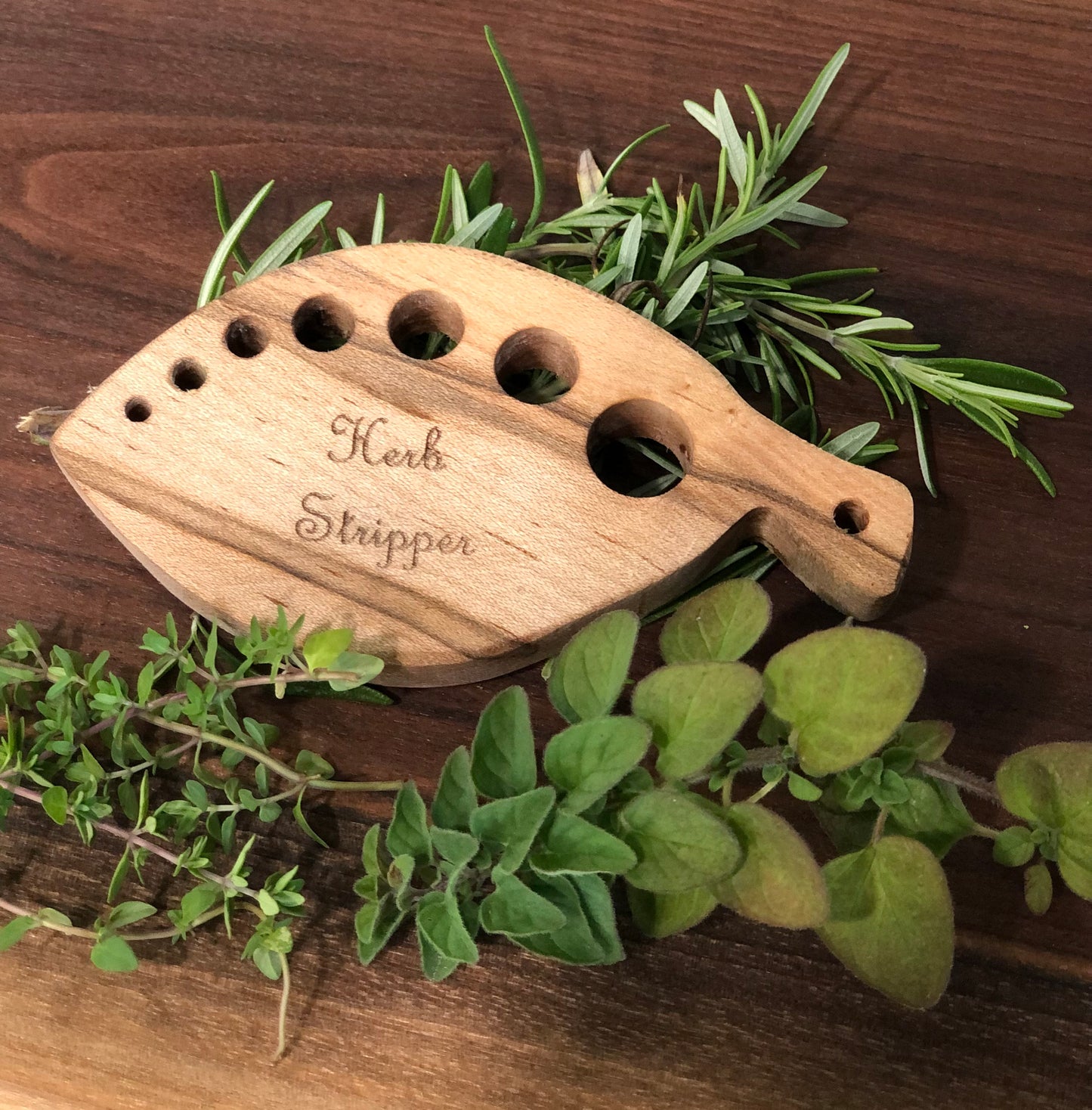 Handmade wood herb stripper used to help prep herbs when cooking. Featuring 7 holes of various sizes to strip the leaves off of different sized herbs.