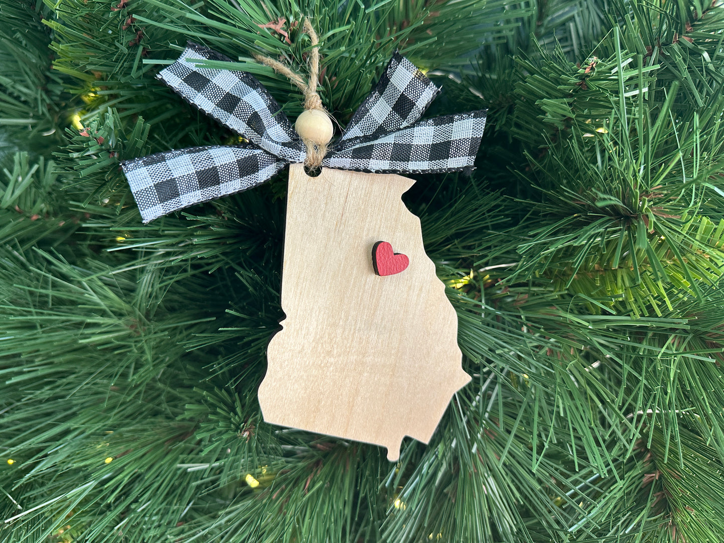 Natural wood Georgia Christmas ornament with a red heart to show your state pride.  Adorned with a black and white buffalo plaid ribbon and wooden bead on twine for easy hanging. 