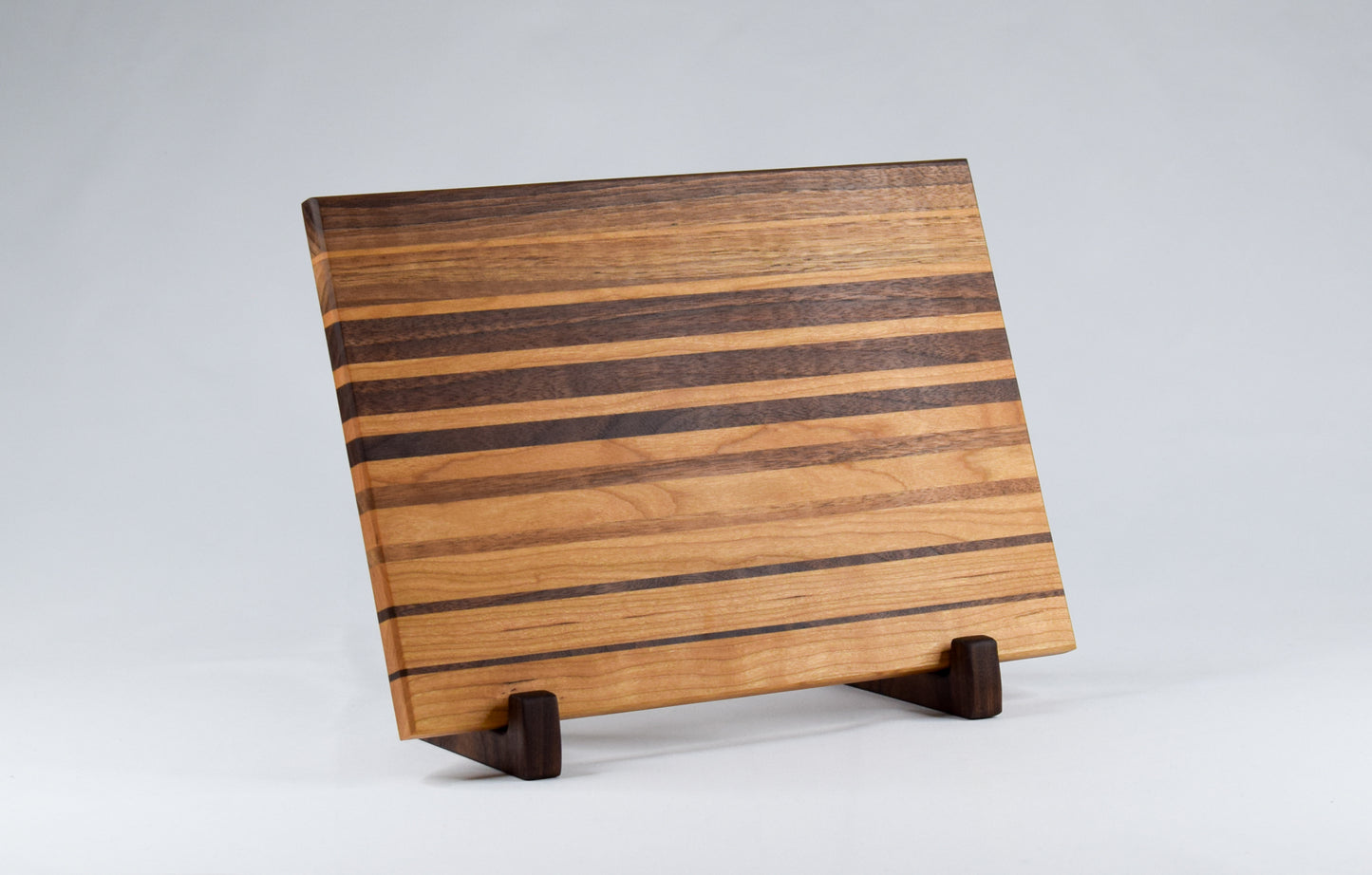 Handmade woodworking gift or decor for those who love to cook. A beautifully handmade cutting board featuring alternating stripes of cherry and walnut woods.