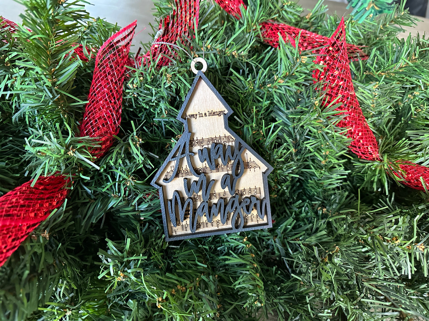 Chapel shaped wooden ornament. Away in a Manger lyrics on a chapel shaped ornament.