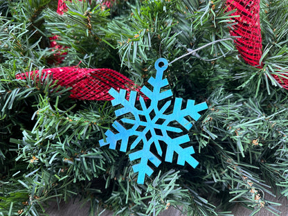 A blue-colored, laser cut snowflake ornament, locally made in Georgia with Birchwood.