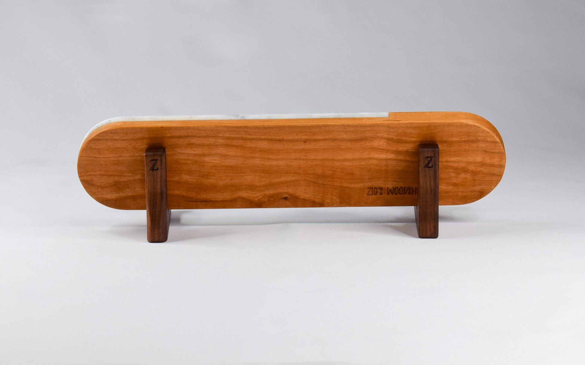 The back of the wood and marble serving board shown on a wooden stand