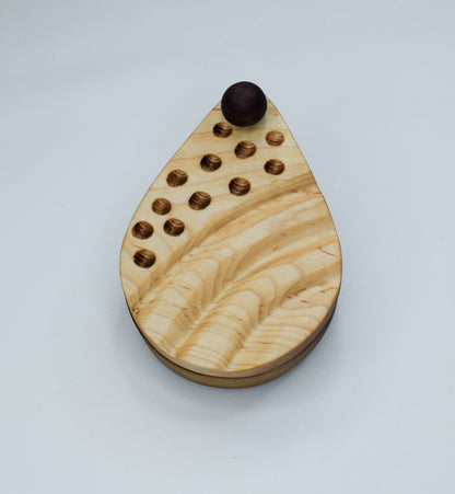 A teardrop shaped salt cellar hand engraved with dot and wave designs on the lid.