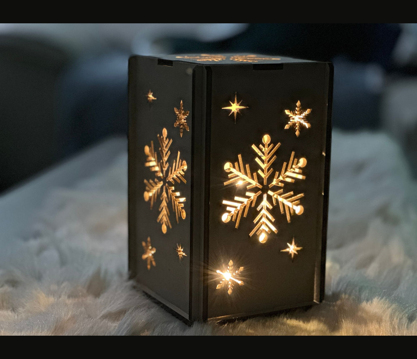 A box shaped wooden lantern with a beautiful snowflake design.