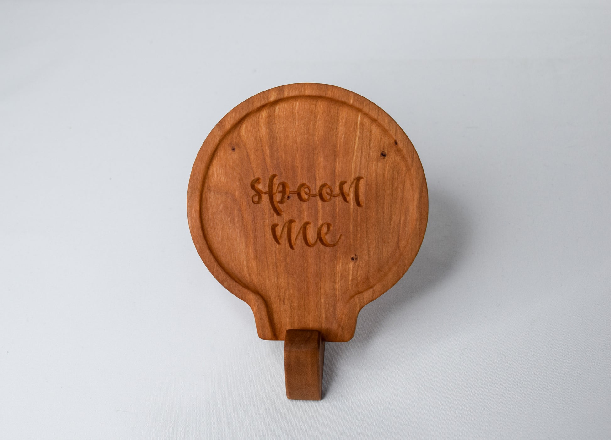 A fun gift idea for those who love to cook - a handmade wooden spoon rest with the saying "spoon me" made out of cherry wood.