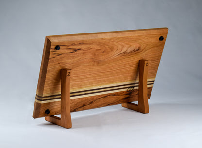 A back view of the striped, rectangular handmade cutting board made of Cherry, Maple, and Walnut.