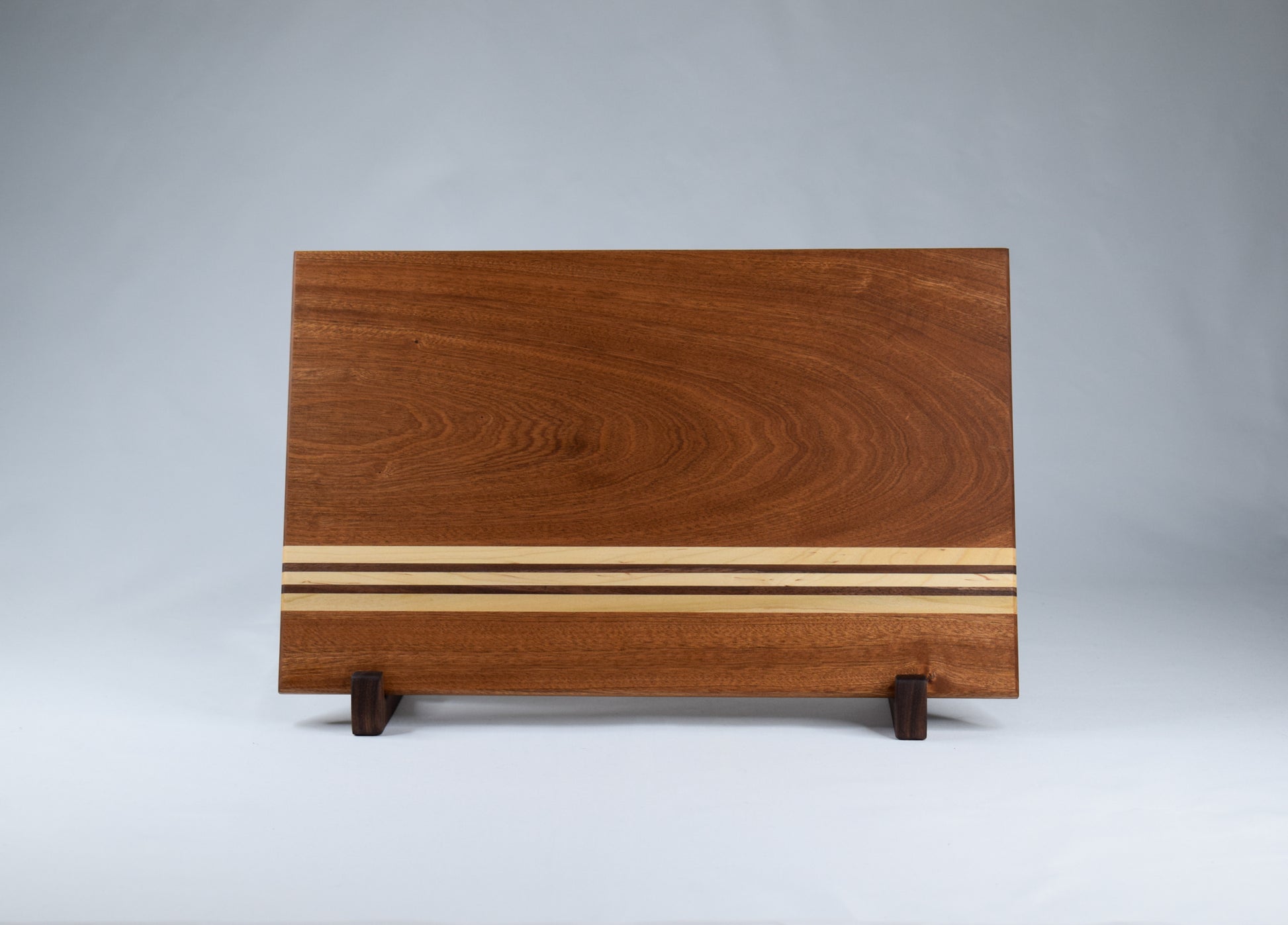 Front view of handmade striped cutting board made of Sapele, Maple, and Walnut.