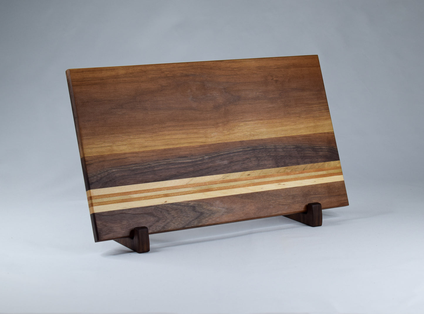 Handcrafted wood gift for the cook in your life. Walnut, Maple, and Cherry wood striped cutting board.