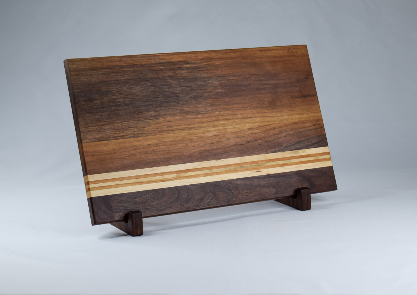 Striped cutting board made of Walnut, Maple, and Cherry hardwoods. Handcrafted in GA.