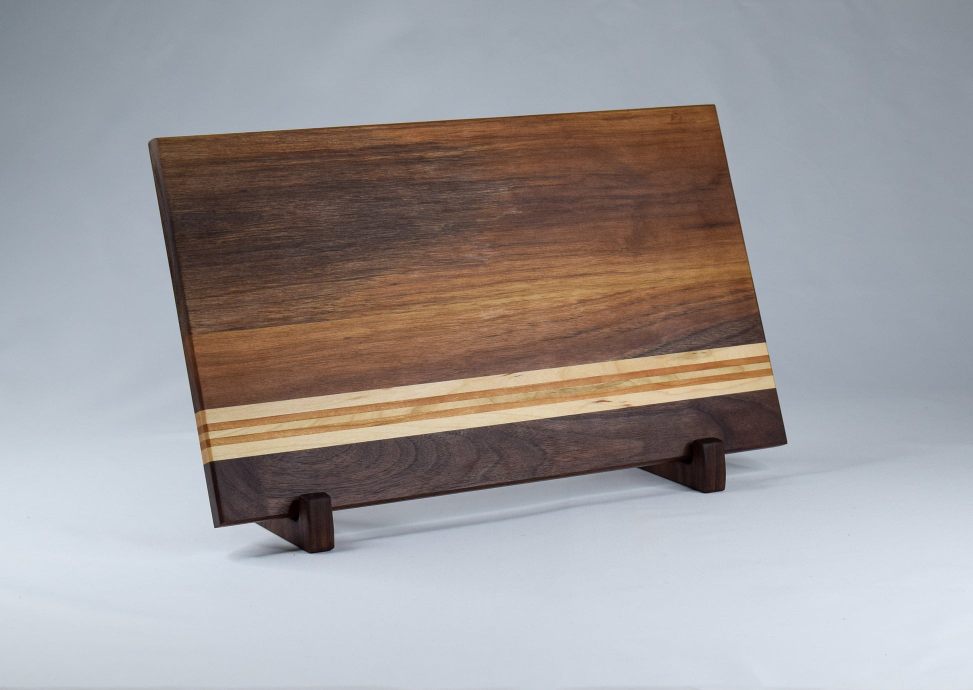 Striped cutting board made of Walnut, Maple, and Cherry hardwoods. Handcrafted in GA.