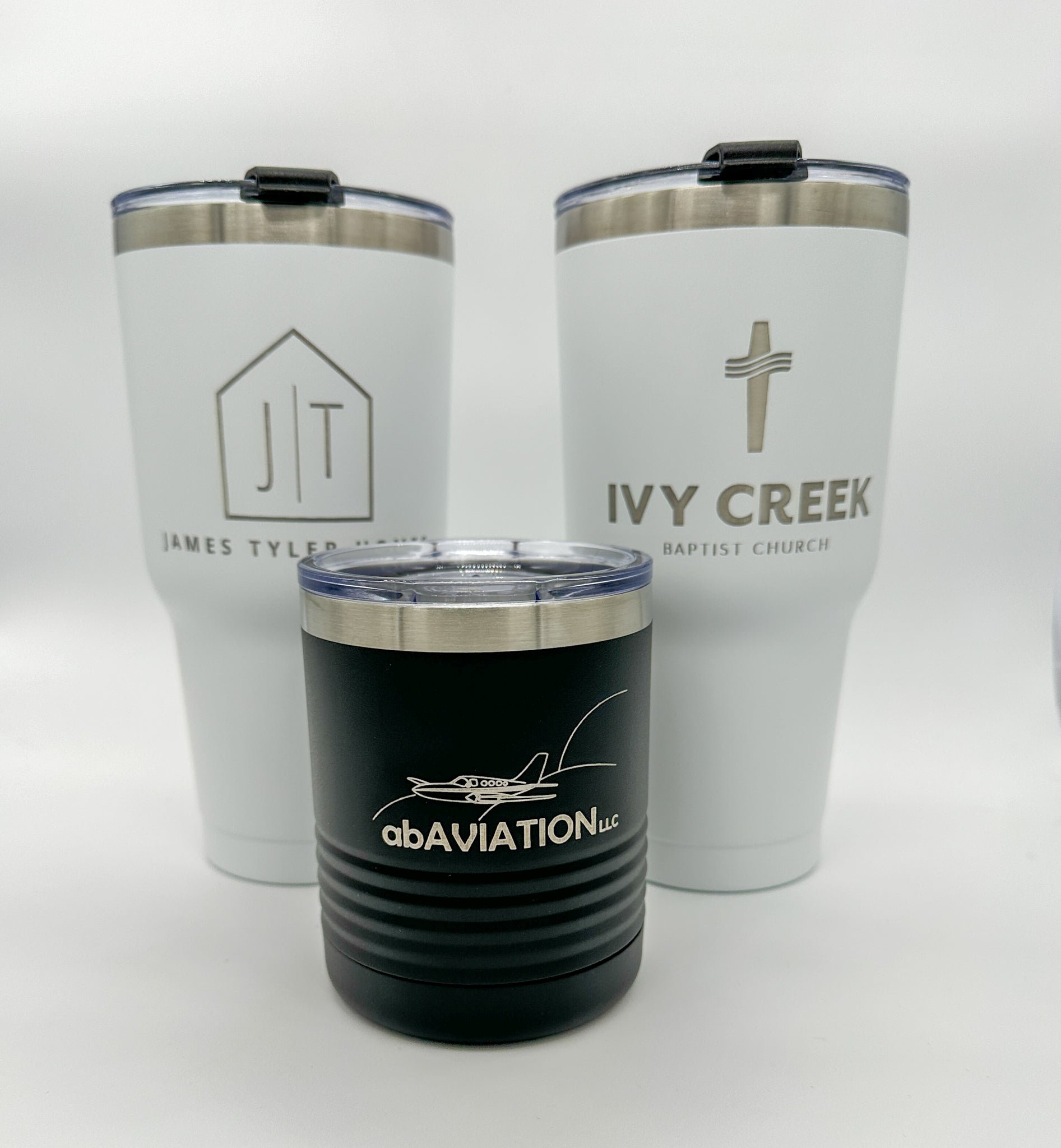 Three different custom tumblers engraved with business names on them. Used to promote business or to gift your clients and employees.