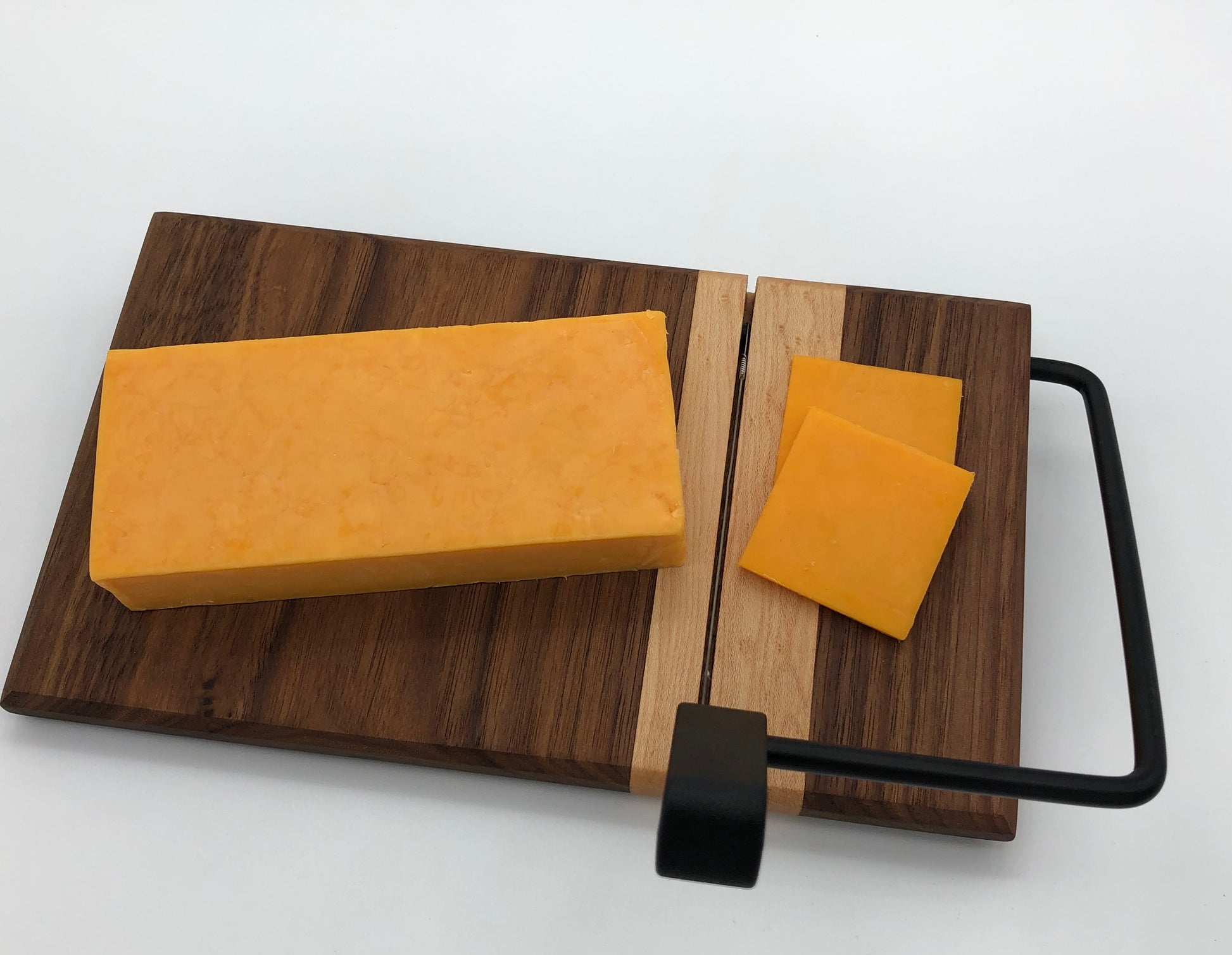 A dark colored wood cheese slicer. Made with locally sourced ambrosia maple and walnut hardwoods.