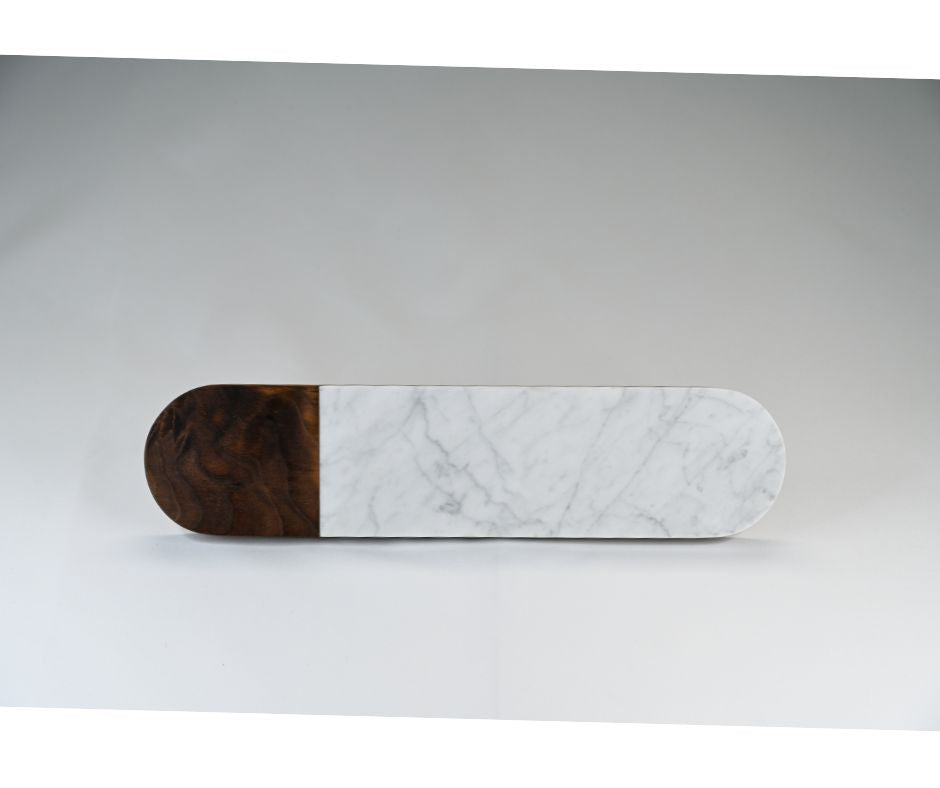 A handmade oval serving board featuring Italian marble and dark walnut wood.