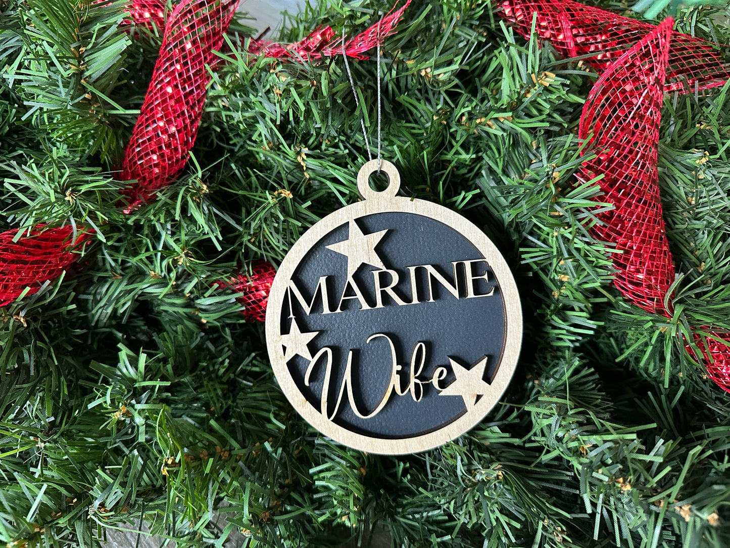 Handmade wood Christmas ornament. Black ornament with light colored birchwood words on top. Words read "Marine Wife."