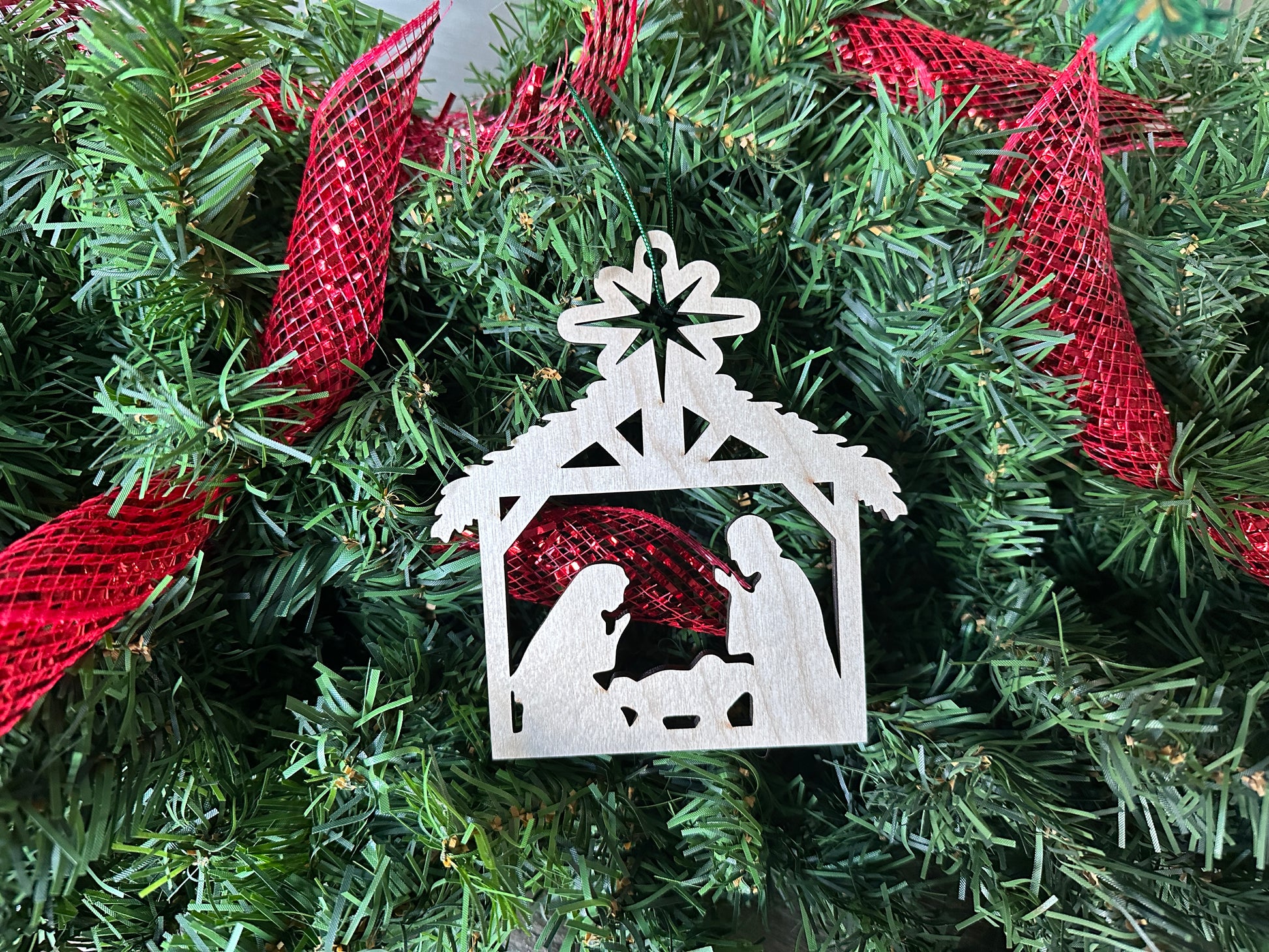 Handmade wooden Nativity Christmas ornament - Mary, Joseph, and Jesus in the manger.