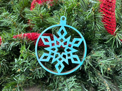 A circle design, blue-colored, laser cut snowflake ornament, locally made in Georgia with Birchwood.