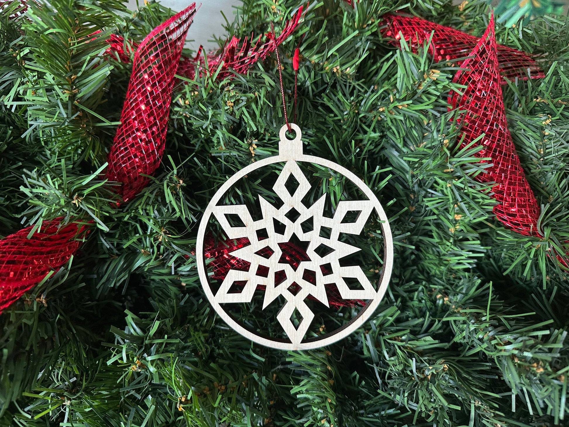 A circle design, natural-colored, laser cut snowflake ornament, locally made in Georgia with Birchwood.