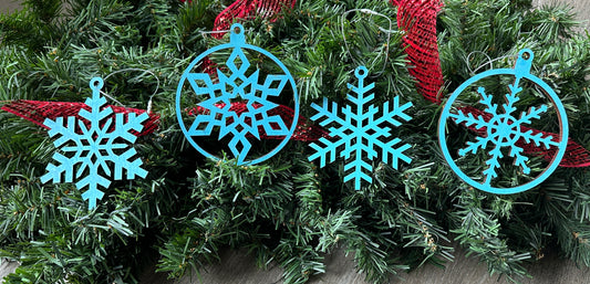 Laser cut snowflake ornaments - four unique snowflake designs, all colored a light blue.