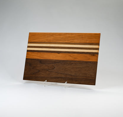 Handmade wooden tray or cutting board featuring a striped design. Made of locally sourced cherry, maple, and walnut wood and handmade in Georgia.