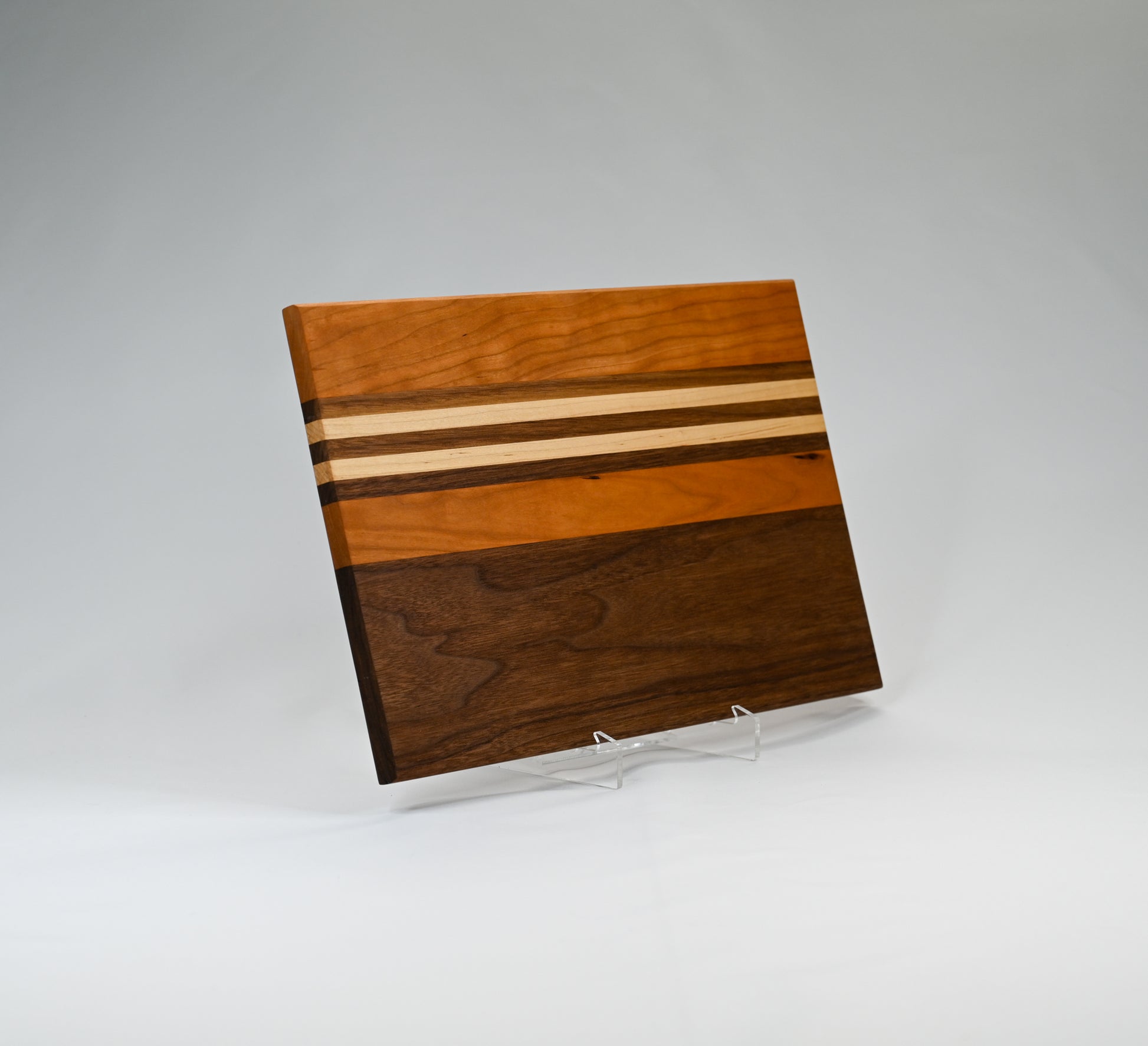 Beautifully handcrafted wood striped cutting board. Made of cherry, maple, and walnut hardwoods.